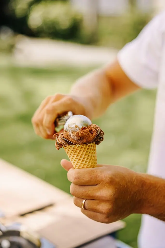 Eis wird mit dem Portionierer in eine Waffel gefüllt