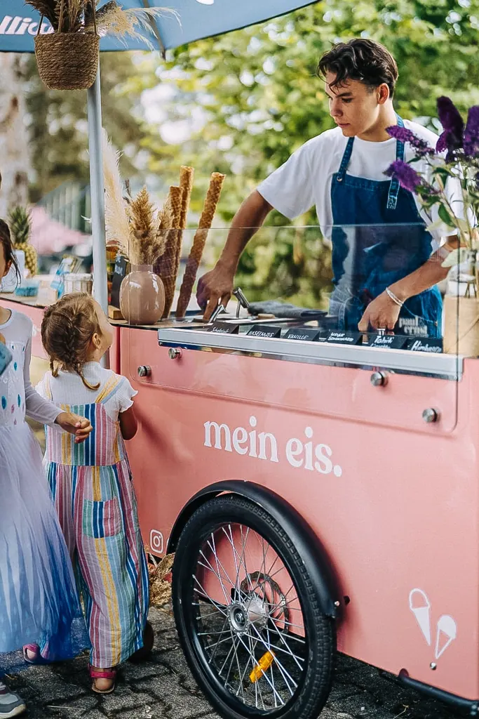 Kind steht am rosa Eisfahrrad von mein eis