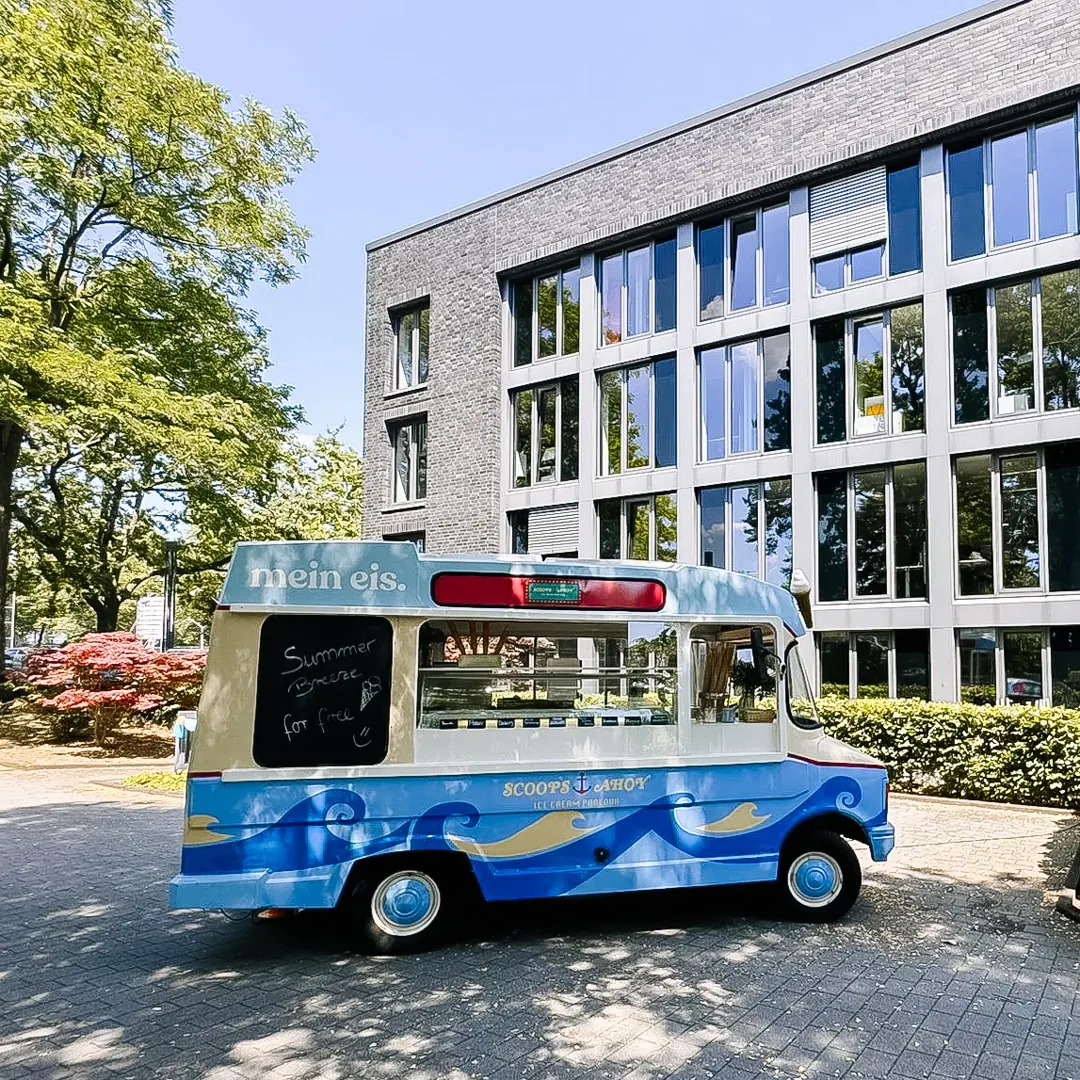 Oldtimer-Eiswagen Kurti von mein eis vor einem Bürogebäude