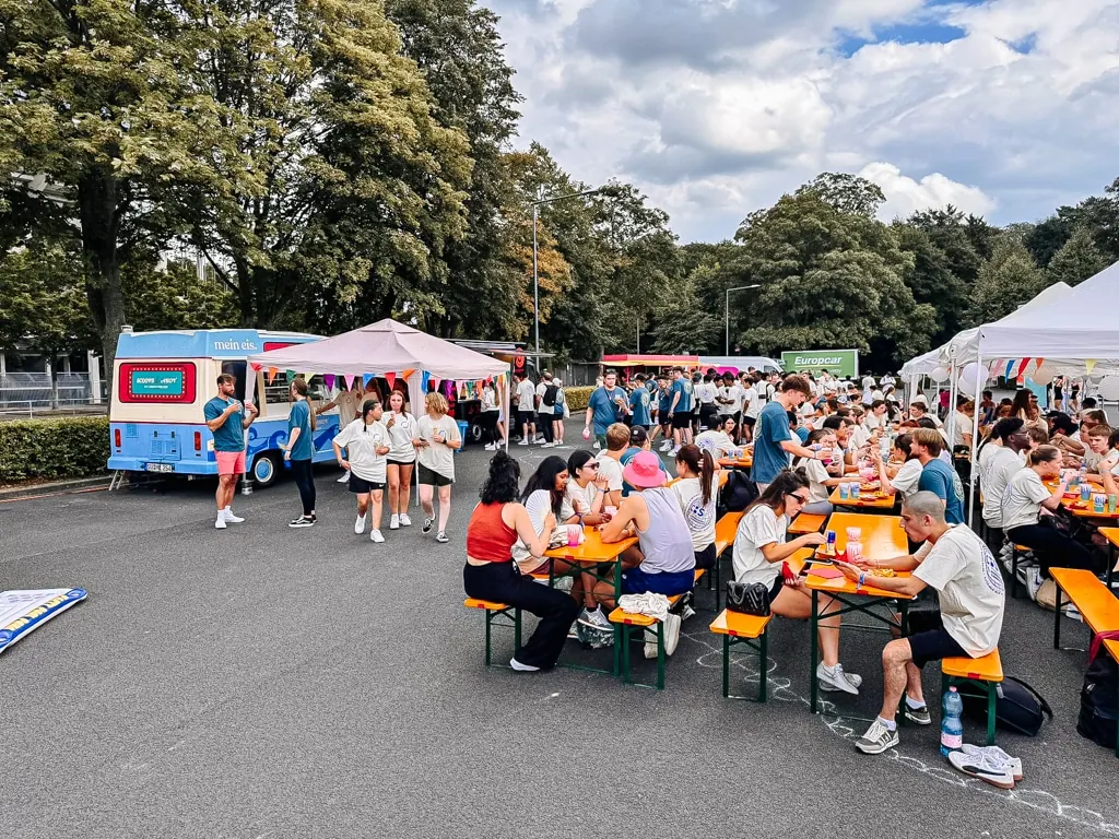 Firmen-Sommerfest mit Bierbänken und Zelten, im Hintergrund der Eiswagen von mein eis