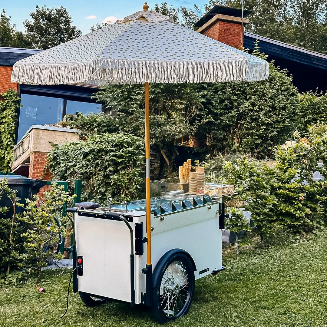 Weißer mobiler Eisstand Minnie von mein eis mit Fransenschirm